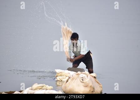 Guwahati, Guwahati, India. 22 novembre 2023. L'uomo lavatore lava i vestiti sulla riva del fiume Brahmaputra a Guwahati Assam India mercoledì 22 novembre 2023 (Credit Image: © Dasarath Deka/ZUMA Press Wire) SOLO USO EDITORIALE! Non per USO commerciale! Foto Stock