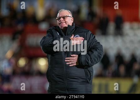 Steve Evans, mentre era capo-allenatore dello Stevenage FC, mostrava ai tifosi la sua lealtà al club, facendo battere il distintivo del club sul petto del cappotto dopo la partita Foto Stock