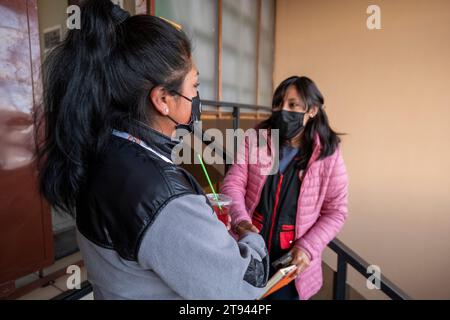 Viacha, la Paz, Bolivia – 16 agosto 2022: Due donne boliviane con maschere parlano insieme in una sala riunioni Foto Stock