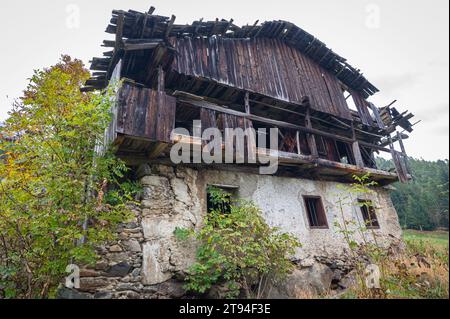 La casa decadente è ricoperta da alberi. Foto Stock