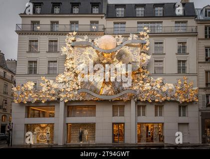 Parigi, Francia - 12 21 2023: Vista della facciata dell'edificio Dior Paris con decorazioni natalizie in un giorno di pioggia Foto Stock