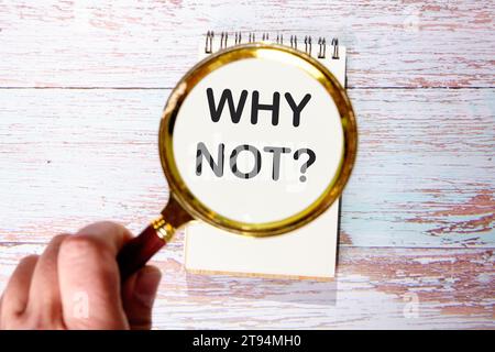 PERCHÉ NOTtext è visibile attraverso lenti di ingrandimento su un blocco note Foto Stock