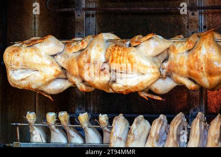 Pollo al forno rotolato su rosticceria venduto in un mercato all'aperto Foto Stock