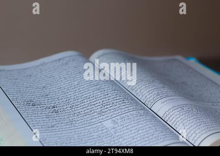 Libro hadith aperto musulmano Sahih che è collocato sul tavolo su sfondo scuro Foto Stock