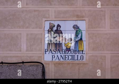 Tradizionale cartello stradale medioevale "Pasadizo del Panecillo" (traduzione: Il passaggio del pane) incorporato nella facciata in mattoni di Madrid, Spagna Foto Stock