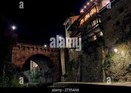 Città medievale di Potes di notte con il ponte e il fiume Deva lungo il suo percorso. Nella regione di Liebana, Cantabria, Spagna. Foto Stock