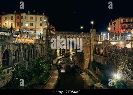 Potes, Cantabria, Spagna 08 02 2023: Città medievale di Potes di notte con ponte e fiume Deva lungo il suo percorso. Nella regione di Liebana, Cantabria, Spagna. Foto Stock