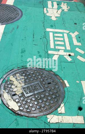 Coperchio del tombino e segnaletica orizzontale, Taipei, Taiwan, Asia. Foto Stock