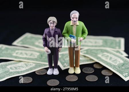 Coppia anziana con banconote da 1 dollaro e centesimi, povertà di vecchiaia Foto Stock
