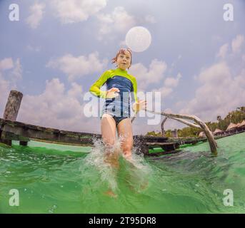 Joyful Boy si tuffa in un lago turchese in Messico Foto Stock