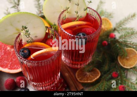 Sangria natalizia aromatica in bicchieri serviti al tavolo, primo piano Foto Stock