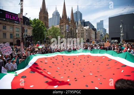 23 novembre 2023, Melbourne, Australia. Gli studenti delle scuole di Melbourne hanno una gigantesca bandiera di anguria, un simbolo della resistenza palestinese, durante un abbandono per protestare contro la guerra in corso a Gaza, creando consapevolezza e chiedendo un cessate il fuoco. Crediti: Jay Kogler/Alamy Live News Foto Stock