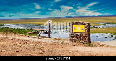 Amboseli, Kenya, 31-dicembre-2020 - Un turista contempla la vasta savana aperta del Parco Nazionale di Amboseli dalla cima della collina di osservazione Foto Stock