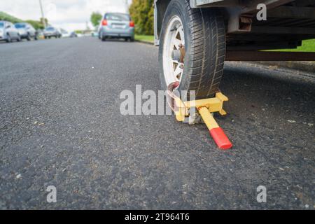 Bloccaggio antifurto del morsetto della ruota posizionato sulla ruota del carrello Foto Stock