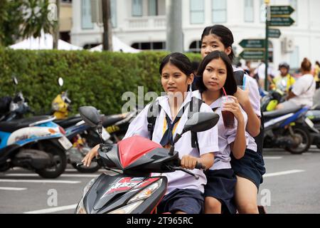 Tre ragazze tailandesi in moto sulla strada cittadina Foto Stock