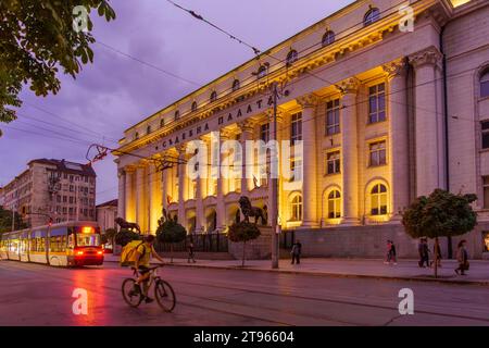 Sofia, Bulgaria - 14 settembre 2023: Vista serale dell'edificio del tribunale cittadino, con un tram, la gente del posto e i visitatori, a Sofia, Bulgaria Foto Stock