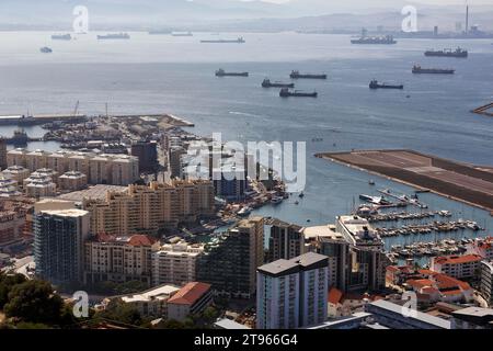 Ammira dalla Rocca di Gibilterra grattacieli, porticciolo e pista, petroliere, navi cargo nella baia di Algeciras nella foschia, Gibilterra Foto Stock