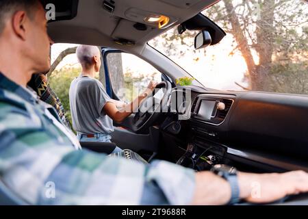donna addossata al furgone che ammira il paesaggio Foto Stock