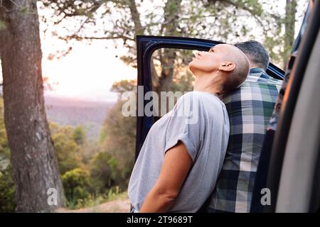coppia appoggiata su un furgone ammirando il paesaggio Foto Stock