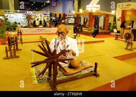 NUOVA DELHI - 20 NOVEMBRE 2023: Stallo di Khadi India che mostra la statua del Mahatma Gandhi alla ruota che gira alla 42a Fiera Internazionale dell'India, essendo h Foto Stock