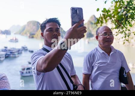 Ha Long Bay, Vietnam - 11 novembre 2023: I turisti sono visti scattare foto nella famosa baia di ha Long, uno dei luoghi turistici più popolari del Vietnam. L'economia vietnamita è una delle più rapide in Asia, ma la sfida dell'ambiente esterno e la minore domanda interna hanno portato a un rallentamento dell'economia vietnamita, con una crescita del 4,7% nel 2023 rispetto all'8% nel 2022, mentre l'industria del turismo continua a crescere, con oltre 10 milioni di visitatori previsti per il 2023, è la destinazione più popolare nel Sud-Est asiatico dopo la Thailandia. (Foto di Davide Bonaldo/Sipa USA) Foto Stock