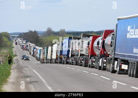 Regione di Leopoli, Ucraina - 18 aprile 2023: Una lunga fila di camion vicino al posto di controllo di frontiera Rava-Ruska sul confine ucraino-polacco. Foto Stock