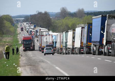 Regione di Leopoli, Ucraina - 18 aprile 2023: Una lunga fila di camion vicino al posto di controllo di frontiera Rava-Ruska sul confine ucraino-polacco. Foto Stock