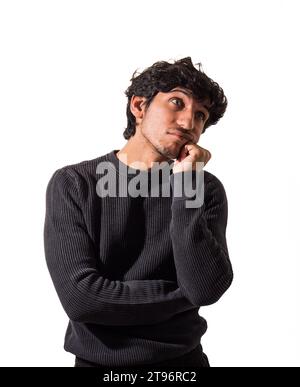 Un uomo con capelli ricci che indossa un maglione nero, che pensa, o deluso o triste, in studio Foto Stock