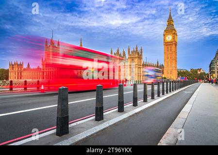 Londra, Regno Unito. Movimento dell'autobus rosso sul Westminster Bridge, ora blu, il Big Ben e l'edificio della House of Commons sullo sfondo, viaggia in inglese. Foto Stock