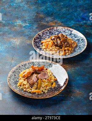 Pilaf uzbeko con carne di agnello in piatto grande. Cucina orientale tradizionale, cibo nazionale, riso profumato chiamato pilaf con carne di agnello e verdure. Pilaf i Foto Stock