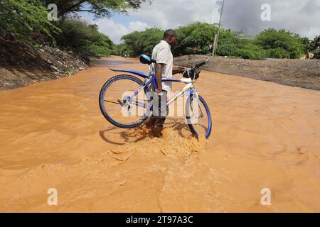 Nairobi. 22 novembre 2023. Un ciclista attraversa una strada allagata a seguito di pesanti pendii nella contea di Garissa, nel nord del Kenya, il 22 novembre 2023. Secondo la società della Croce Rossa del Kenya, almeno 71 persone sono morte, più di 200 feriti e più di 150.000 altri sfollati in tutto il paese, mentre le forti piogge continuano a causare disordini. Crediti: Joy Nabukewa/Xinhua/Alamy Live News Foto Stock