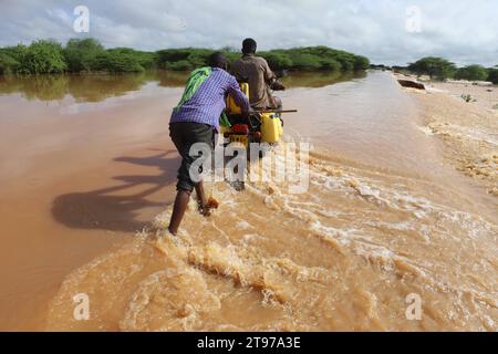 Nairobi. 22 novembre 2023. Le persone attraversano una strada scavata dall'acqua a seguito di pesanti pendii nella contea di Garissa, nel nord del Kenya, il 22 novembre 2023. Secondo la società della Croce Rossa del Kenya, almeno 71 persone sono morte, più di 200 feriti e più di 150.000 altri sfollati in tutto il paese, mentre le forti piogge continuano a causare disordini. Crediti: Joy Nabukewa/Xinhua/Alamy Live News Foto Stock