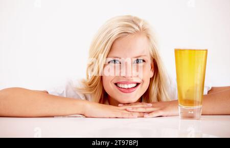 Donna, ritratto e sorriso con birra in studio per il relax del fine settimana, bevanda estiva su sfondo bianco. Persona femminile, viso e modello o alcool Foto Stock