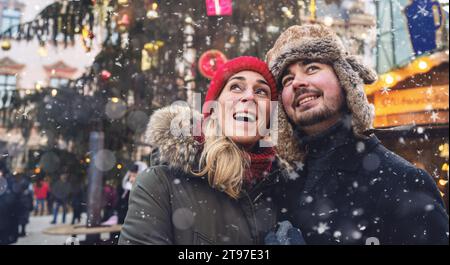 Donna e uomo al mercatino di Natale di fronte all'albero Foto Stock