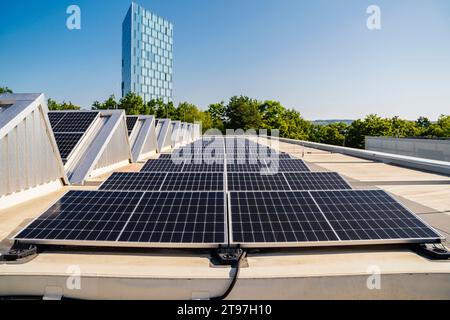 Pannelli solari installati su un tetto, che generano energia pulita sotto un cielo azzurro Foto Stock