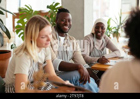 Baristi sorridenti seduti e chiacchierando al bar Foto Stock