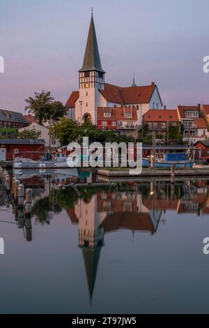 Danimarca, Bornholm, Ronne, Chiesa di San Nicola che si riflette nelle acque costiere al crepuscolo Foto Stock