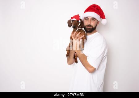 Giovane con il suo cane da dachshund isolato su sfondo bianco. Foto Stock