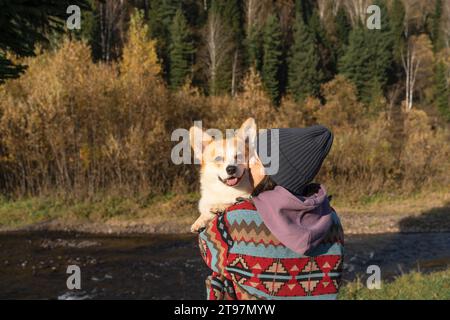 Giovane donna che abbraccia il corgi gallese Pembroke nel parco nel fine settimana Foto Stock