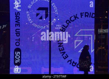 Londra, Regno Unito. 23 novembre 2023. Una passeggiata pedonale passa davanti a una promozione del Black Friday in un negozio in Oxford Street nel centro di Londra. Credito: Vuk Valcic/Alamy Live News Foto Stock