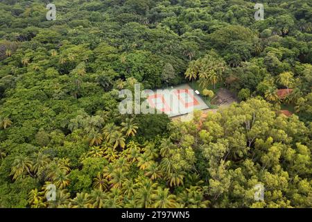 Campo da tennis vuoto intorno alle palme verdi vista aerea droni Foto Stock