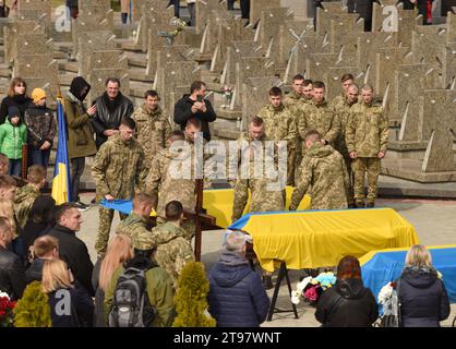 Leopoli, Ucraina - Marc 29, 2022: I militari coprono la bara dei militari ucraini uccisi durante l'invasione russa dell'Ucraina con un ucraino Foto Stock