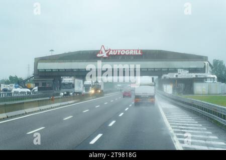 Fontanellato, Italia - 10 maggio 2023: Ristorante e bar Autogrill in una giornata piovosa con cieli cupi su un'autostrada in Italia. Foto Stock