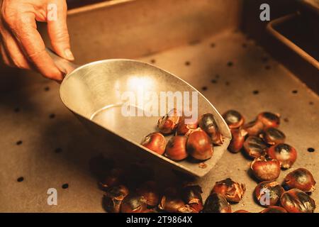 Castagne arrostite in una paletta metallica al mercatino di Natale Foto Stock
