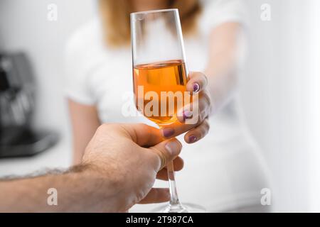 Una donna incinta prende un bicchiere di vino da mans Hand. Donna dipendente dall'alcol Foto Stock