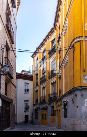 Madrid, Spagna, 09.10.21. Stretta strada di ciottoli medievale spagnola a Madrid con case residenziali, balconi tradizionali e lampioni in stile antico. Foto Stock