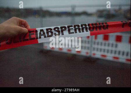 Flensburg, Schleswig-Holstein, Fast einhundert Meter der Hafenkante am Flensburger Hafen West sind abgesackt, der Bereich wurde abgesichert, hier: Absperrband, Sicht Nord Richtung Süden mit Hafenspitze und Jürgensby. Aufnahme vom 23.11.2023, Flensburg, Hafen West *** Flensburg, Schleswig Holstein, quasi cento metri del bordo del porto di Flensburg Harbour West sono affondati, la zona è stata messa in sicurezza, qui nastro barriera, vista da nord a sud con punta del porto e Jürgensby foto scattata il 23 11 2023, Flensburg, Harbour West Credit: Imago/Alamy Live News Foto Stock