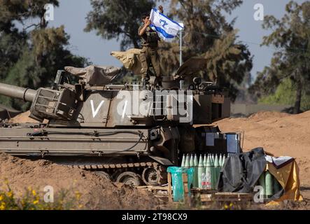 Israele meridionale, Israele. 23 novembre 2023. Un soldato israeliano nel corpo d'armatura pone una bandiera israeliana sul suo semovente Howitzer da 155 mm in una base militare nel sud di Israele vicino al confine con la Striscia di Gaza il 23 novembre 2023. Il 24 novembre Israele e Hamas cominceranno un cessate il fuoco e scambieranno 50 ostaggi israeliani per 150 prigionieri palestinesi detenuti in Israele. Il cessate il fuoco durerà cinque giorni, con circa 12 ostaggi rilasciati ogni giorno. Foto di Jim Hollander/UPI Credit: UPI/Alamy Live News Foto Stock