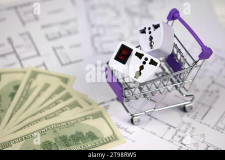 Standard degli Stati Uniti outlet USA in un piccolo carrello per la spesa su progetti di case residenziali da vicino. Concetto di acquisto e dispositivi elettrici Foto Stock