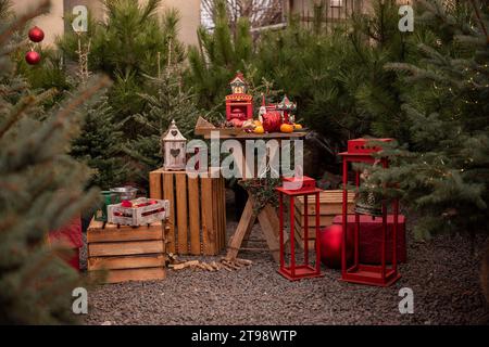 Luogo festivo per decorare il mercato all'aperto dell'albero di Natale in città. Fiera delle vacanze, decorazione del cortile. Colore rosso alla moda per lanterne, candelabri, Foto Stock